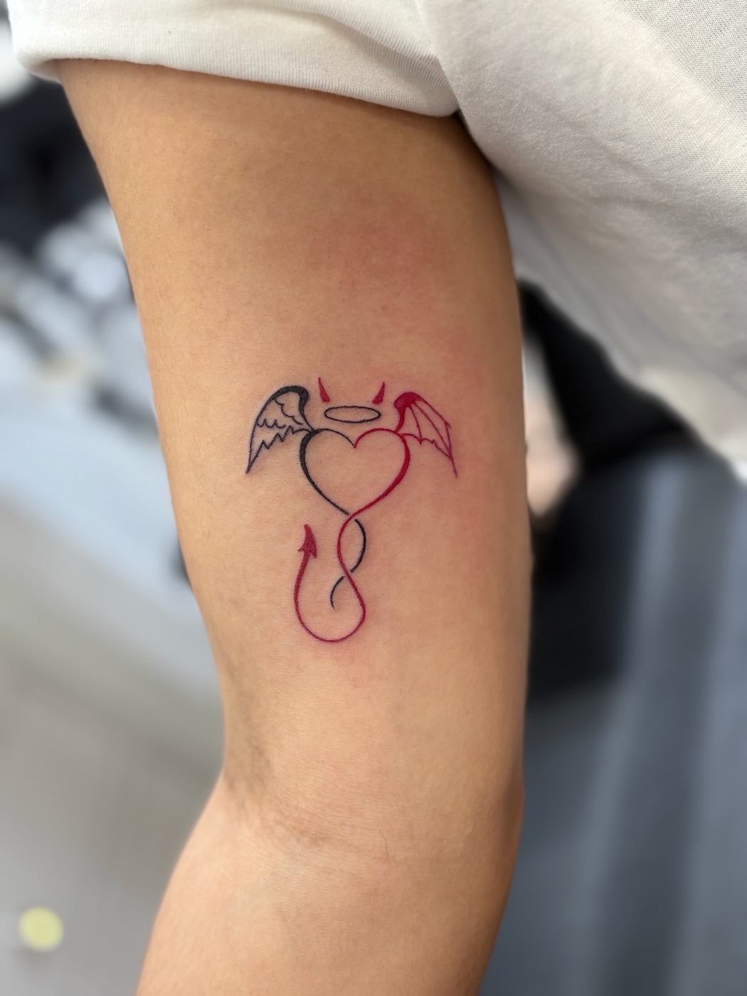 Heart with angel and demon wings color tattoo by Caitlyn Barbosa