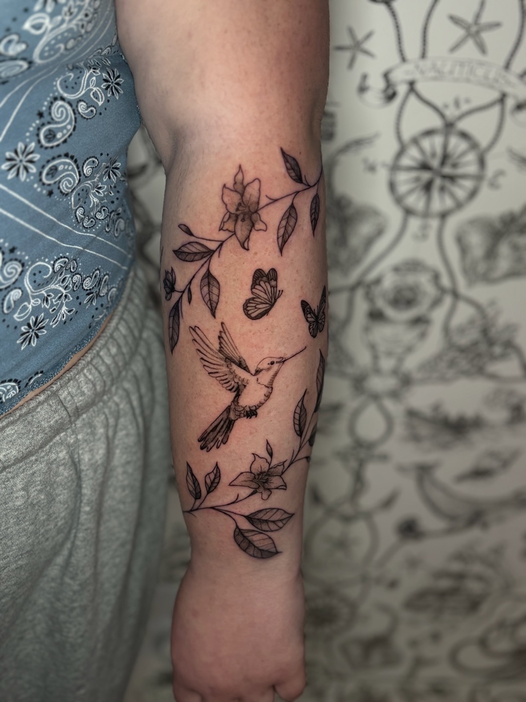 Bird with flowers and leaves fine line tattoo by Caitlyn Barbosa